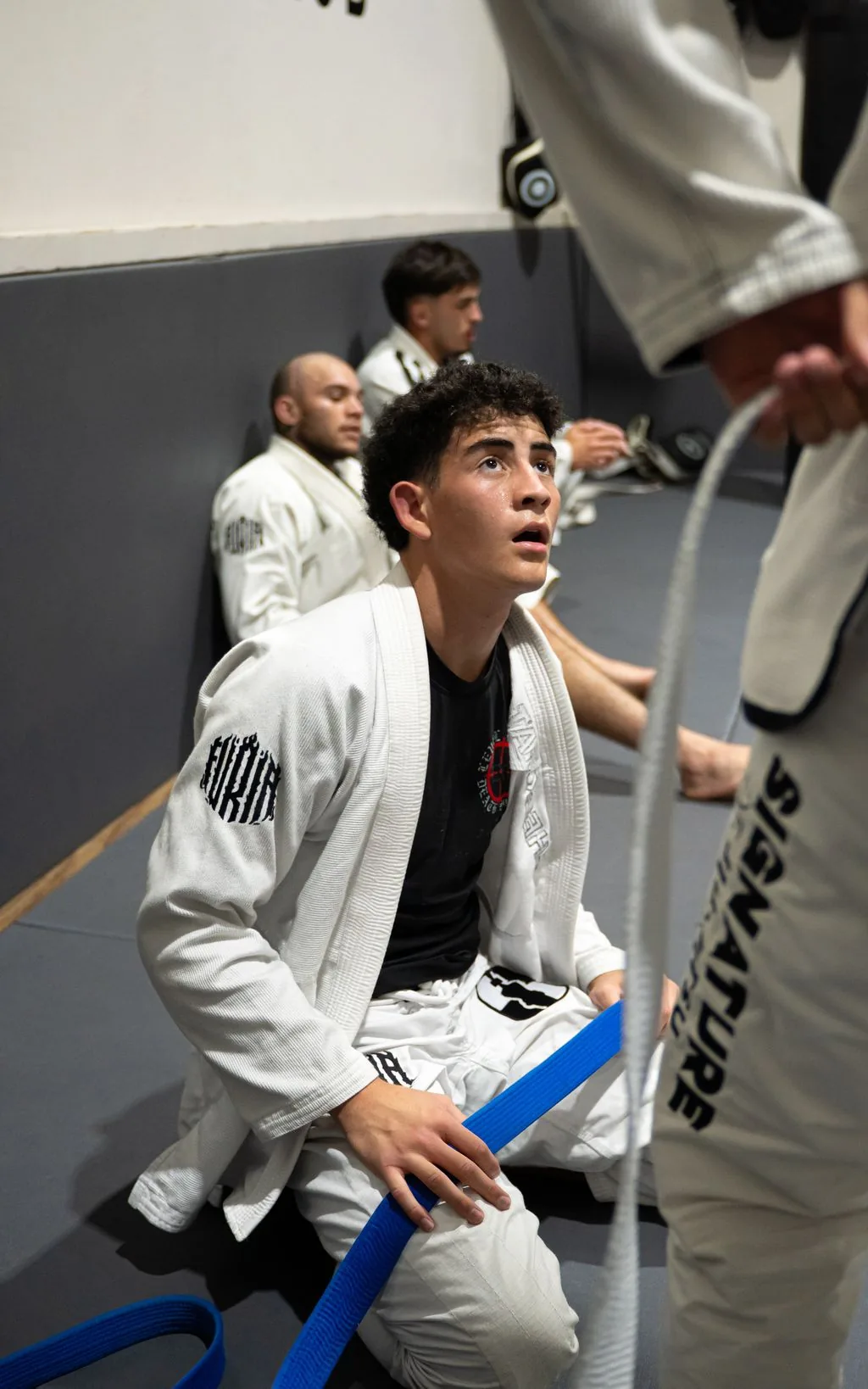 A Brazilian Jiu-Jitsu athlete practicing a grip in the gi