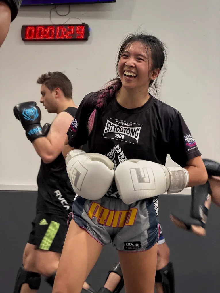 A Muay Thai student smiling during a class at Fúria Fight Club